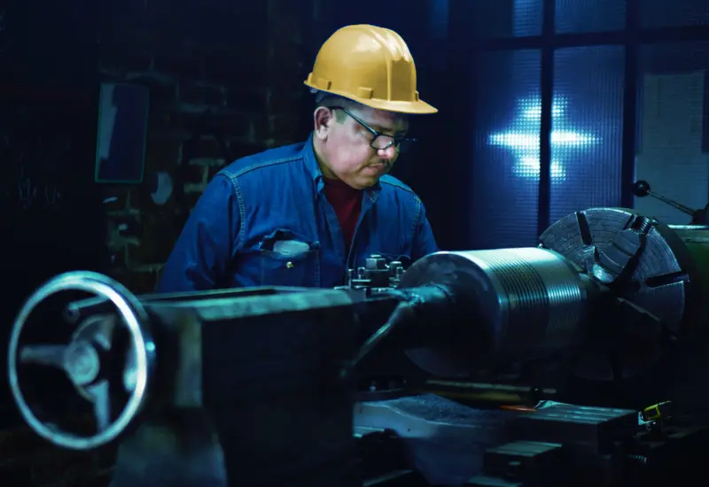 Un ingeniero dándole mantenimiento al equipo industrial de la empresa.